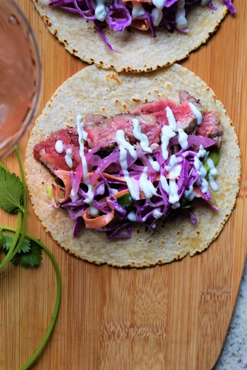 Steak Tacos with Cabbage Slaw, Lime Crema & Pickled Red Onions